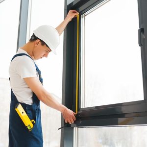 Professional handyman installing window at home.